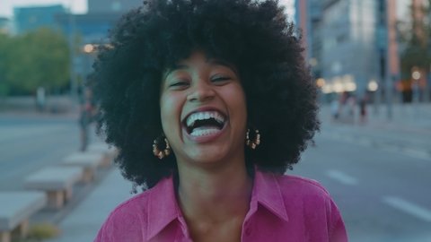Cinematic video of a self confident young woman spending time in a modern city. Millennial girl with afro hairstyle lifestyle moments.	 Video de stock