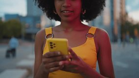 Cinematic video of a self confident young woman spending time in a modern city. Millennial girl with afro hairstyle lifestyle moments.	
