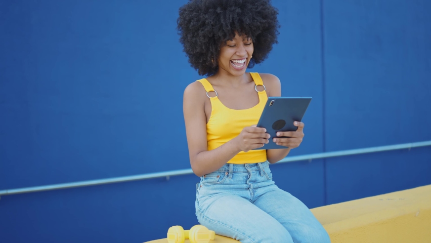 Cinematic video of a self confident young woman spending time in a modern city. Millennial girl with afro hairstyle lifestyle moments.	