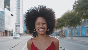 Cinematic video of a self confident young woman spending time in a modern city. Millennial girl with afro hairstyle lifestyle moments.	