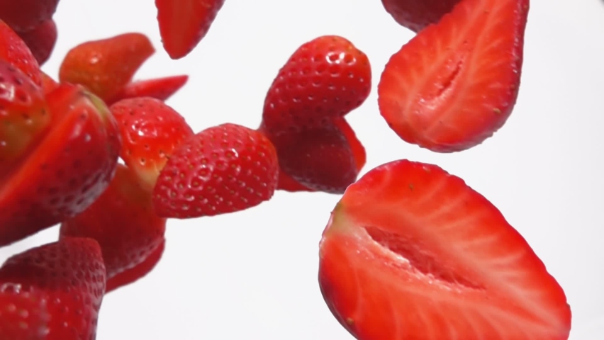 Close-up of the sweet red strawberry slices falling diagonally on a white background in slowmotion | Shutterstock HD Video #1097467139