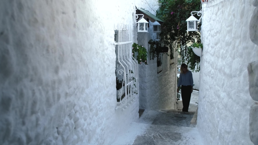 a woman walks along the narrow white street of the city of Marmaris Turkey