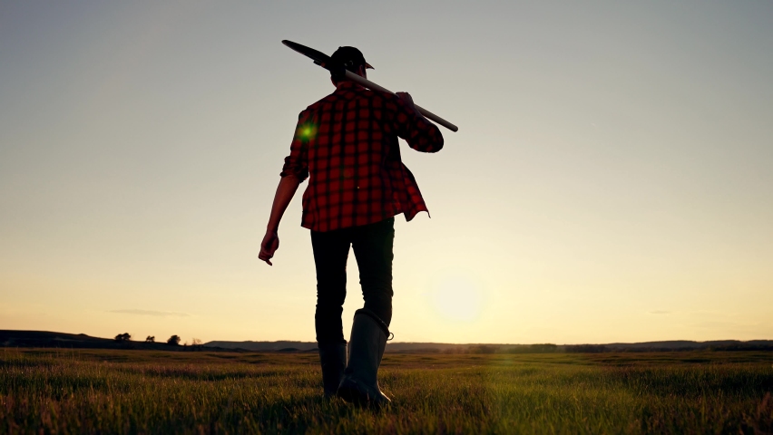 Farmer works on plowed field at sunset outdoors with shovel. Agronomist walks through plowed field with shovel shoulder. concept of agriculture, work in village outdoors. work of farmer agronomist. Royalty-Free Stock Footage #1097472401