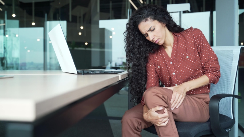 Business woman has severe pain in leg muscle spasm varicose veins, massaging Female employee suffers from sprained joint acute pain indoors sitting at the workplace Worker feeling calf painful Royalty-Free Stock Footage #1097478209