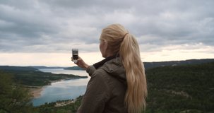 Travel, woman hiking and taking phone pictures for happy memory mock up. Sunset, adventure and female hiker recording video of beautiful landscape and river with 5g mobile smartphone for social media