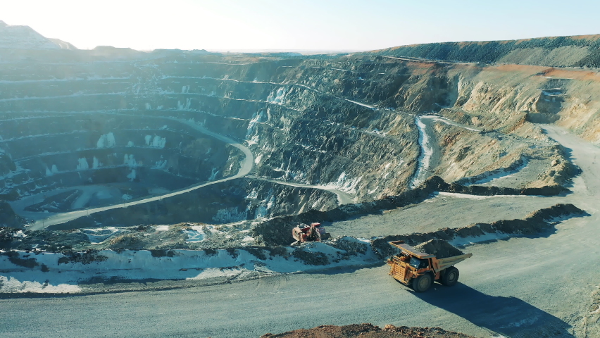Open pit with machines riding around it. Mining industry concept.