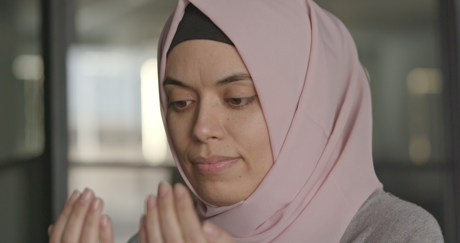 Muslim woman in headscarf prays with her hands up in air | Shutterstock HD Video #1097483203