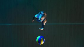 Top view of a young woman hitting ball on wooden floor, tossing and hitting the ball in jump. Female athlete works out skills of serving ball on volleyball court in blue light. - Powered by Shutterstock - Get 15% off with code: PIKWIZARD15