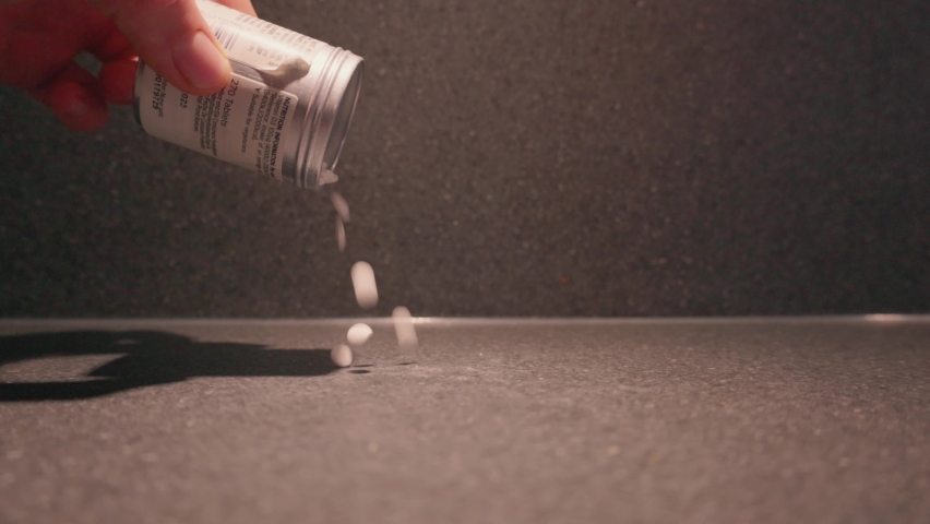 Pills from container spilling onto table, medicine | Shutterstock HD Video #1097486521