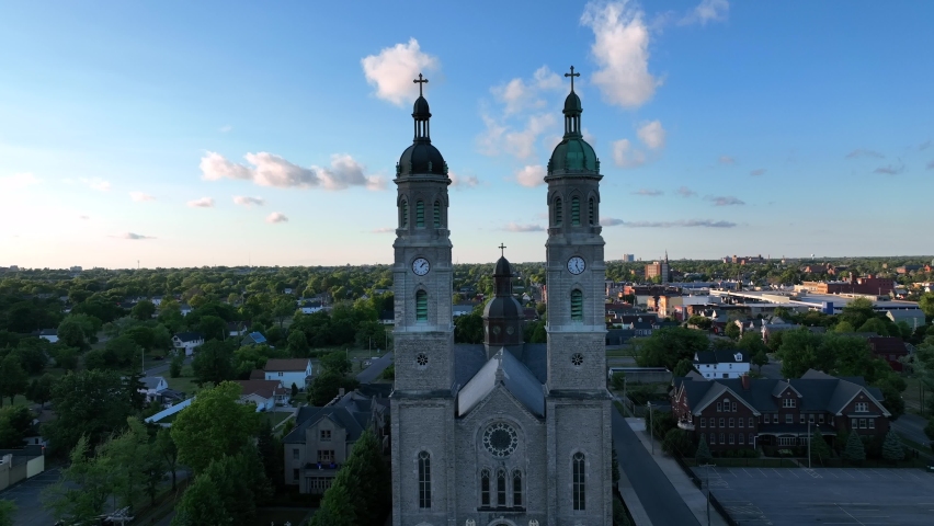 An aerial view of the Saint Stanislaus B and M Roman Catholic Church spires in Buffalo, New York in the light of the setting sun.