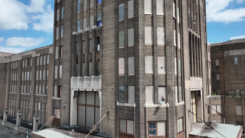 A ascending view of the architecture and brick front of the Grand Central Station in Buffalo, New York with the city in the background.