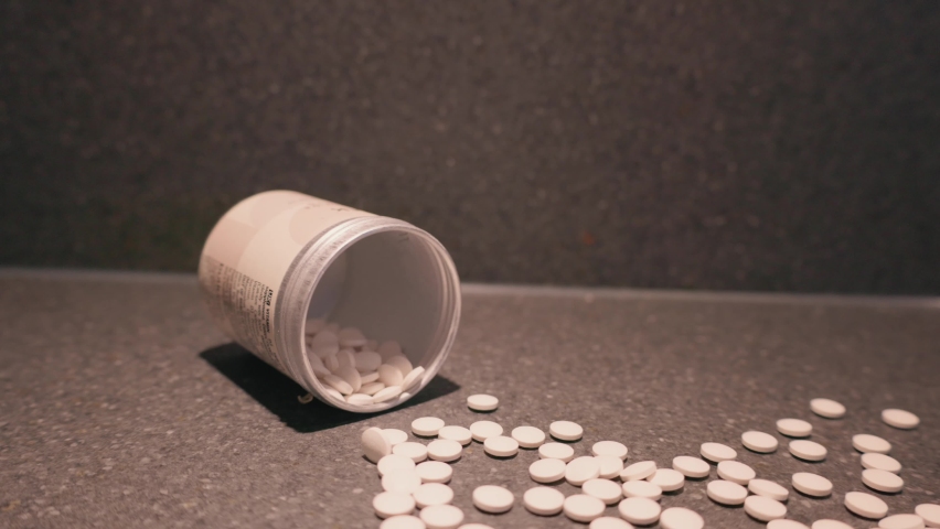 Pills from container spilling onto table, medicine | Shutterstock HD Video #1097487529
