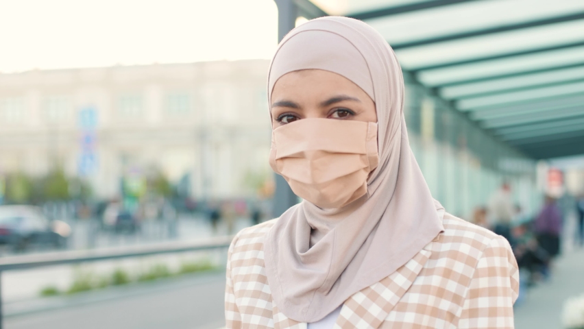 Muslim woman in medical mask showing an International Vaccination Certificate on smartphone. QR code of vaccinated person on cellphone app. Close up concept. Digital health passport | Shutterstock HD Video #1097489047