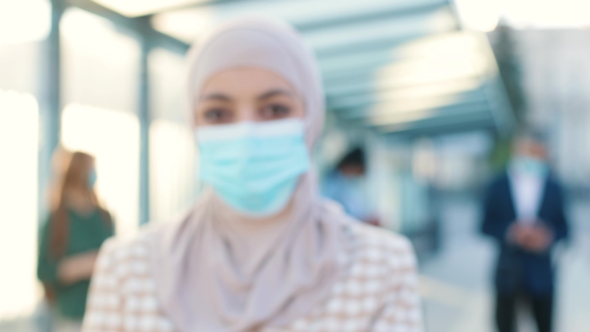 Muslim women in medical mask showing an International Vaccination Certificate COVID-19 QR code on smartphone. Close up concept. Vaccinated person using digital health passport app in mobile phone | Shutterstock HD Video #1097489065