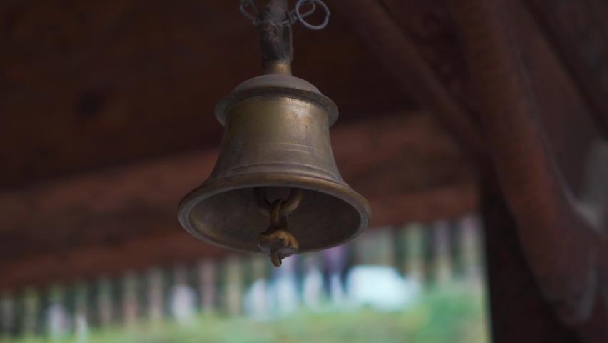 Closeup shot of hand of an Indian man ringing the temple bell inside the Tripura Sundari Temple in Naggar near Manali in Himachal Pradesh, India. Devotee ringing bell in the temple for prayer to god.  | Shutterstock HD Video #1097496285
