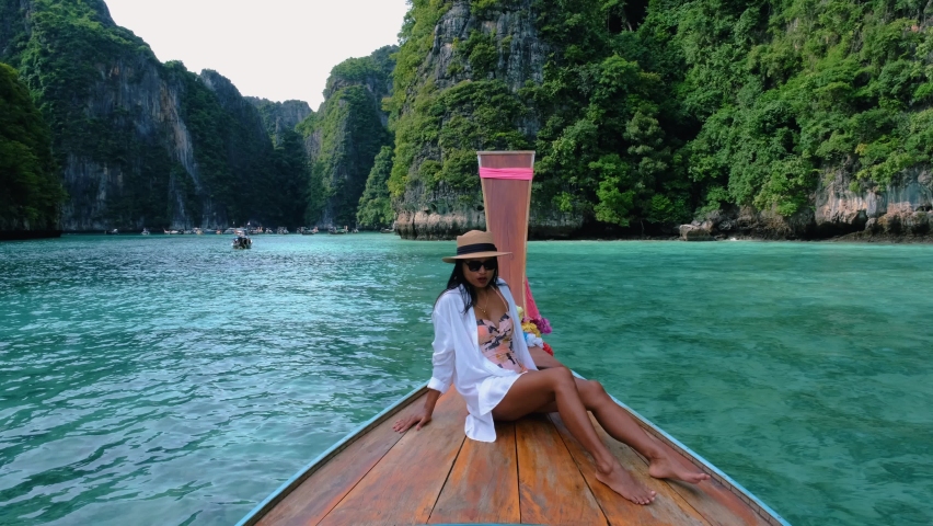 Pileh Lagoon with the green emerald ocean at Koh Phi Phi Thailand, women in front of longtail boat | Shutterstock HD Video #1097497495