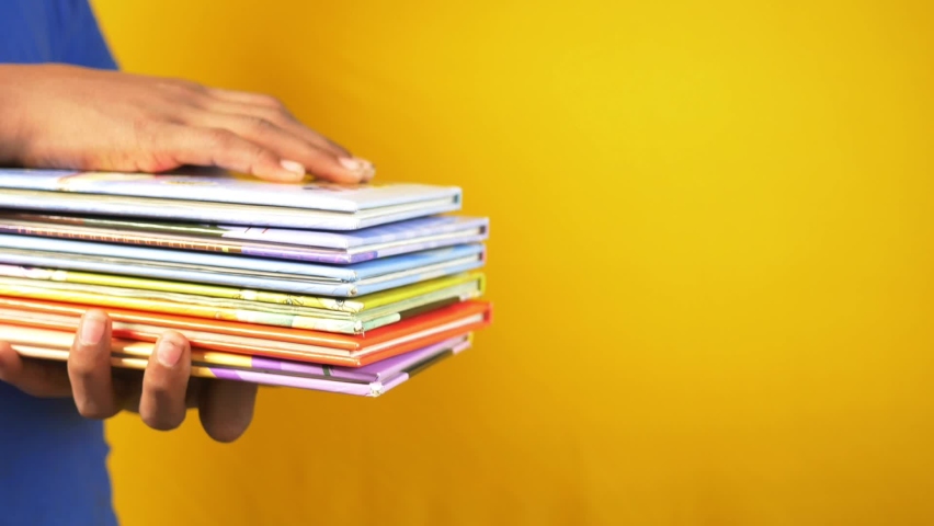 Hand holding stack of books on color background  | Shutterstock HD Video #1097498433