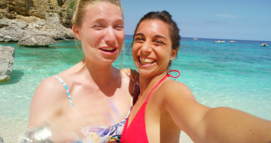 Friends, beach and travel with women and selfie video or social media live, face and wave for camera on holiday by the ocean. Blowing kiss, sea and adventure on summer vacation portrait in Italy. | Shutterstock HD Video #1097503831