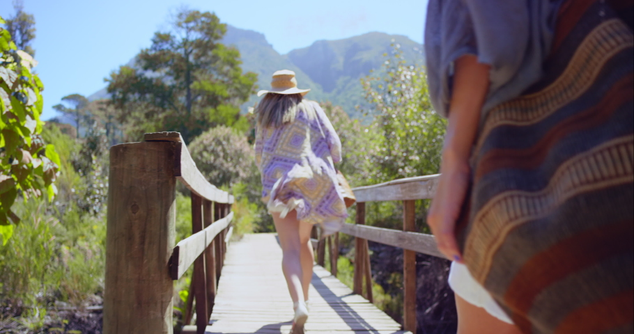 Friends, running and bridge with women playful on a bonding, carefree vacation together in nature. Best friends, friendship and girls run on a footpath in a forest while having natural fun | Shutterstock HD Video #1097503851