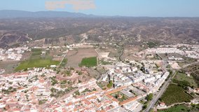 Silves - Portugal. Aerial perspective of Portuguese city situated in Algarve province. Panoramic view of the city with church and castle in top of the hill. Beautiful River Arade. Drones pull back 