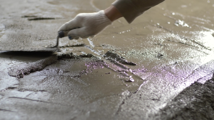 Close-up of a construction worker leveling a concrete screed with a trowel or putty knife Royalty-Free Stock Footage #1097509733