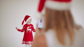 Mother recording her daughter in xmas clothes.
