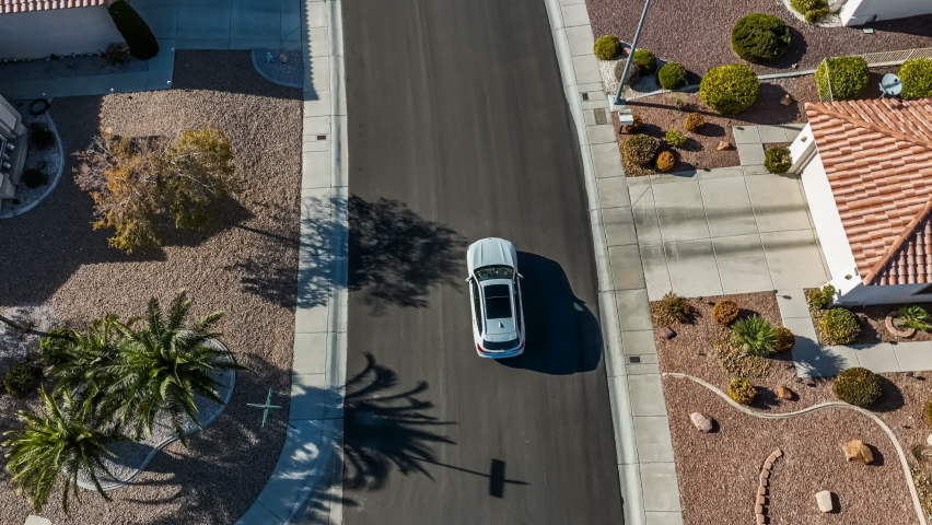 Aerial view of a car driving away on a suburban neighborhood road in Nevada; 4k footage | Shutterstock HD Video #1097514721