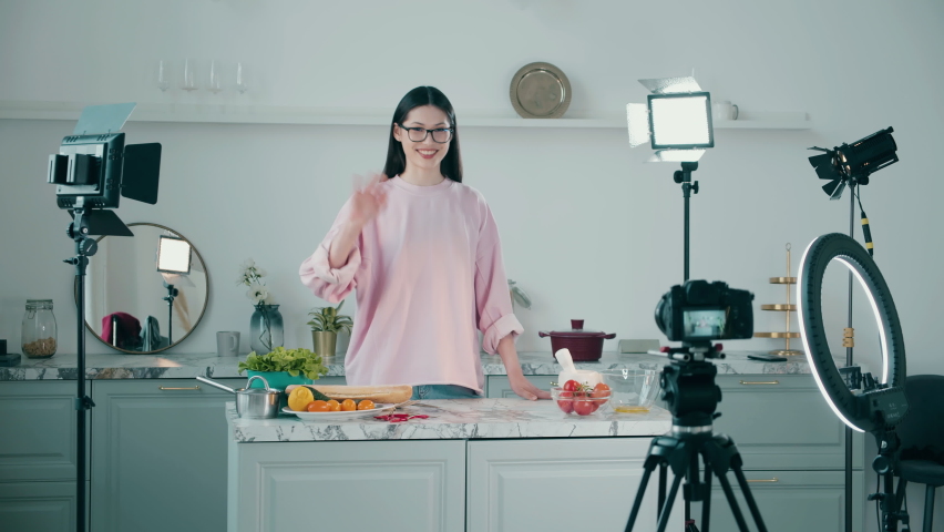 Young lady is getting filmed while cooking in the studio kitchen | Shutterstock HD Video #1097516257