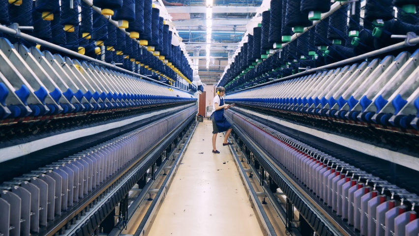 Female worker is inspecting threads in the textile factory unit