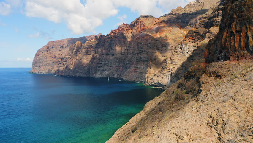 Aerial spectacular view of Los Gigantes. Drone flight over huge cliff rocks. Tranquil deep blue waters of Atlantic ocean. Tenerife. Trip to the paradise island. Journey, volcanic seascape. | Shutterstock HD Video #1097519773