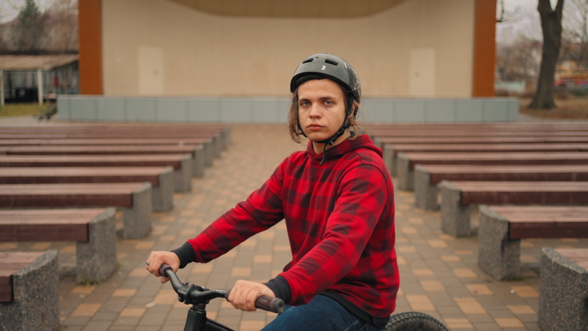 Teen boy on bmx bike in park, portrait of adolescent loving sport and extreme, bicyclist in helmet | Shutterstock HD Video #1097525225
