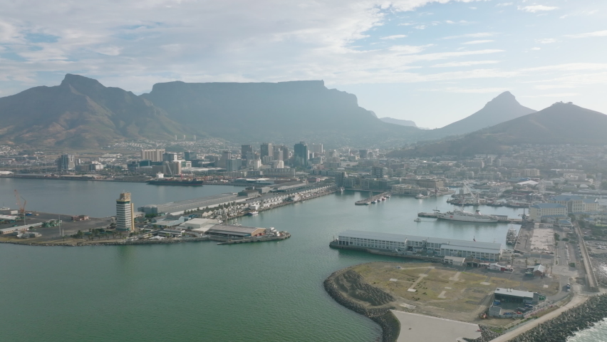 Aerial view of harbour and buildings on waterfront. Tall buildings in city centre and famous Fable mountain in background. Cape Town, South Africa