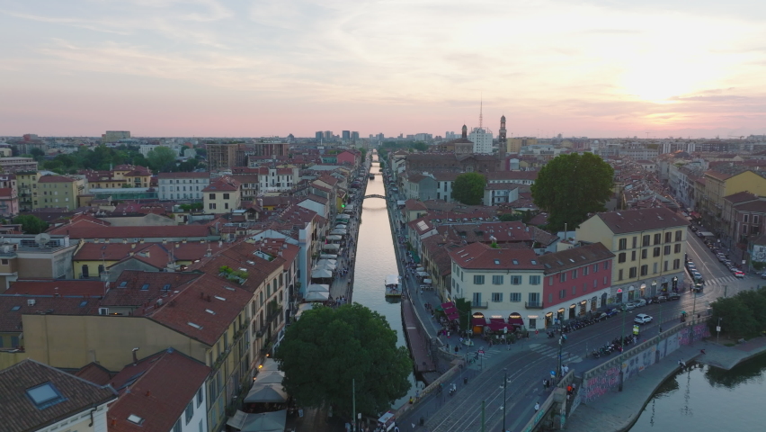 Forwards fly above Naviglio Grande water canal and surrounding buildings at twilight. Historic tourist attraction. Milano, Italy Royalty-Free Stock Footage #1097527097