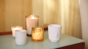 Aromatic burning candles on table at home. Decoration, hygge and aromatherapy concept. Video