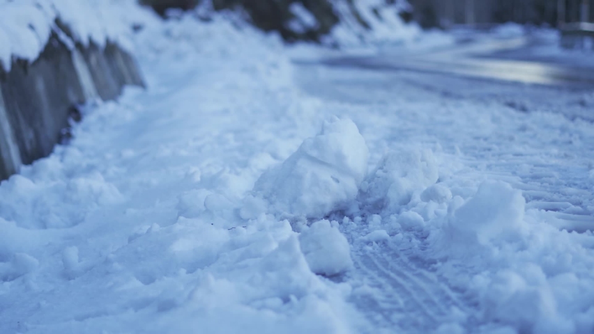Closeup shot of snow on the side of the road at Solang Valley in Manali, Himachal Pradesh, India. Blocks of snow and ice on the side of the road after snowfall during winter season in Manali. | Shutterstock HD Video #1097533041
