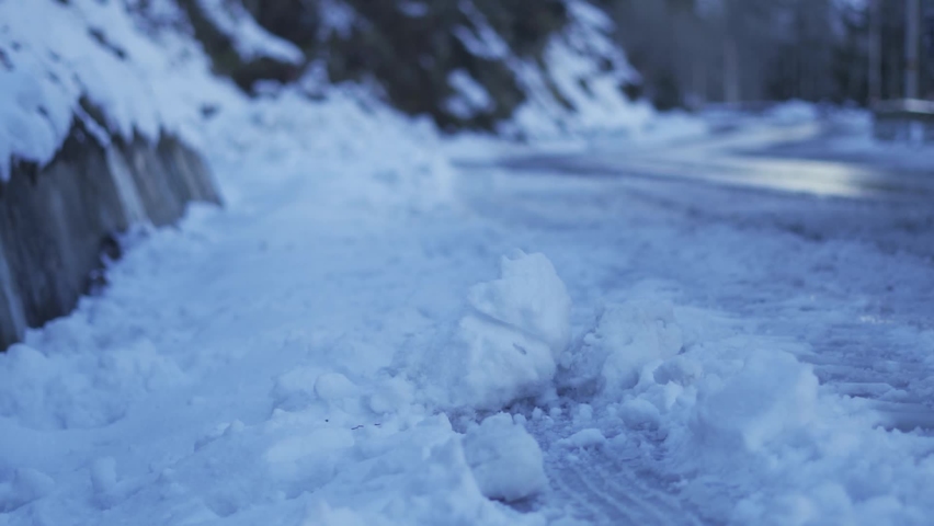 Closeup shot of snow on the side of the road with truck moving in road in background at Solang Valley in Manali, Himachal Pradesh, India. Selective focus on the snow with truck out of focus.  | Shutterstock HD Video #1097533047