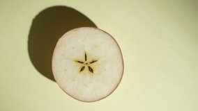 Half fresh apple rotating on the sunlight on a colored yellow background, close up, top view. Food concept  - Powered by Shutterstock - Get 15% off with code: PIKWIZARD15
