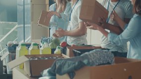 Charity, Donation, and Volunteering Concept - Group of Happy Smiling Volunteers Sorting Humanitarian Aid at Distribution or Refugee Assistance Center. Volunteer Warehouse - Powered by Shutterstock - Get 15% off with code: PIKWIZARD15