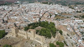 Aerial view of medieval Moorish castle of Alcazaba of Antequera on background with cityscape on sunny fall day, Malaga, Spain. High quality 4k footage
