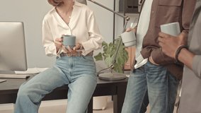 Low angle of four cropped colleagues having break in office at daytime, pouring and drinking black coffee, chatting - Powered by Shutterstock - Get 15% off with code: PIKWIZARD15