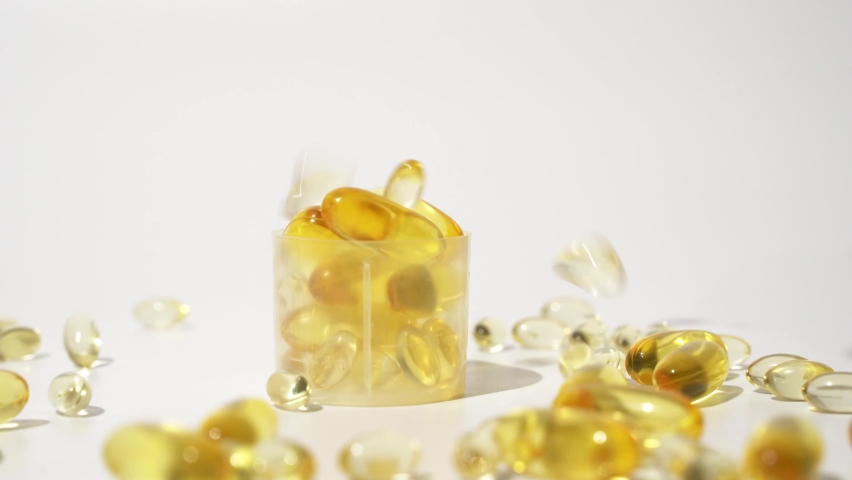 Transparent golden pills falling on white background. Oil pills capsule Skin care medical Europe 4k | Shutterstock HD Video #1097563745