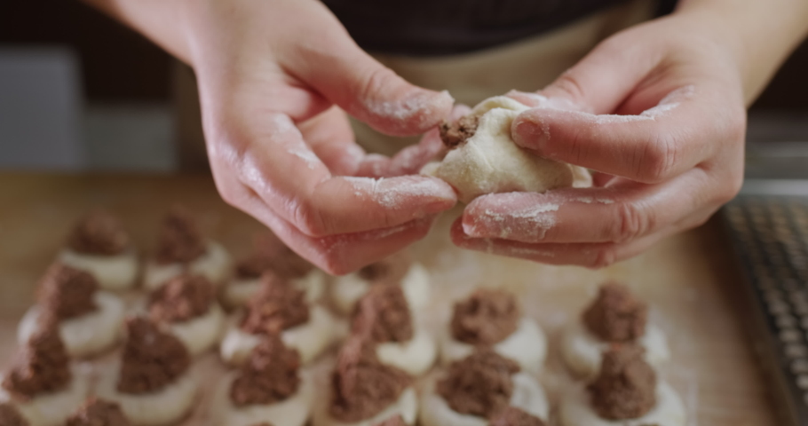 Baker's hands sculpt dumplings with meat filling | Shutterstock HD Video #1097563763