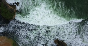 Overhead drone shot of sea wave on the rocky beach - Tropical beach with greenish water