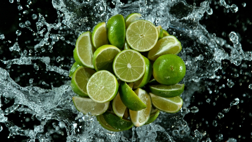 Super slow motion of lime slices with splashing water, black background. Filmed on high speed cinema camera, 1000 fps. Top shot.  | Shutterstock HD Video #1097573685
