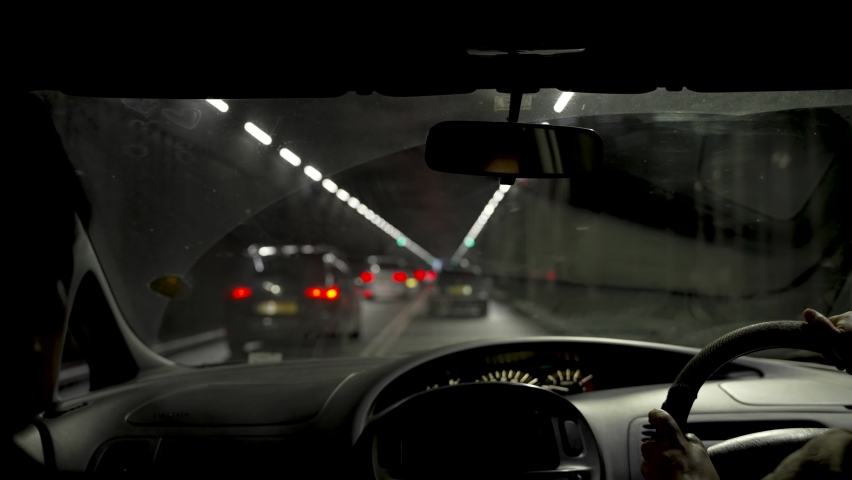 POV Inside Car Driving Through Dark Tunnel Road Near Heathrow Airport. Slow Motion Royalty-Free Stock Footage #1097577449