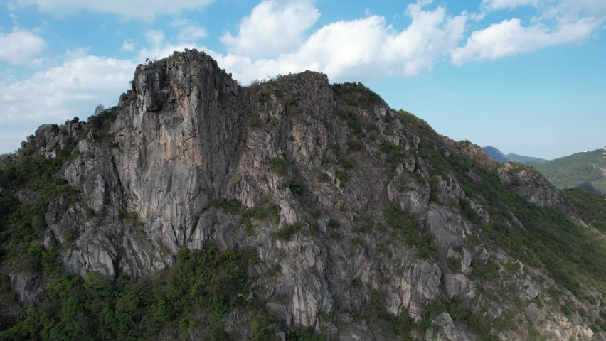 City skyview in Hong Kong 4K Aerial drone shot of the Lion Rock mountain traditional stone trails, characterized by rugged escarpments, it resembles a lion sitting regally near Kowloon Peninsula