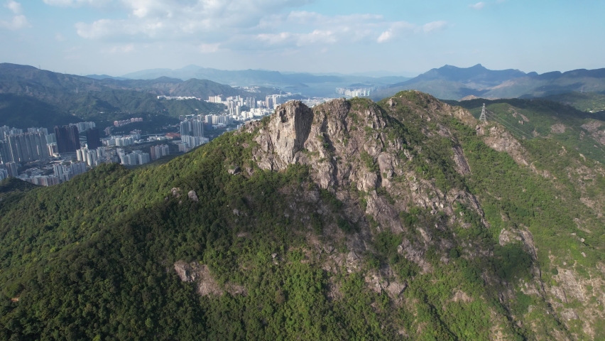 City skyview in Hong Kong 4K Aerial drone shot of the Lion Rock mountain traditional stone trails, characterized by rugged escarpments, it resembles a lion sitting regally near Kowloon Peninsula