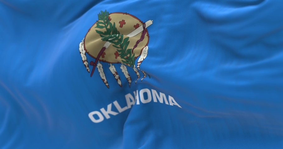 Close up view of the Oklahoma state flag waving. Oklahoma is a state of the United States. Fabric textured background. Selective focus. Seamless loop in slow motion. Realistic 3D render
