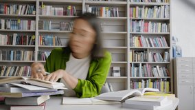 Young Asian teacher writes theses of lecture using scientific books in library. Thorough preparation for educational process using actual literature time lapse - Powered by Shutterstock - Get 15% off with code: PIKWIZARD15