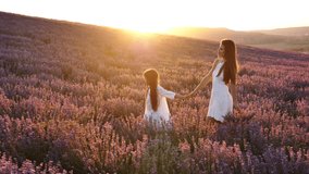 Mother and little daughter on a blooming lavender field at sunset. Slow motion. - Powered by Shutterstock - Get 15% off with code: PIKWIZARD15
